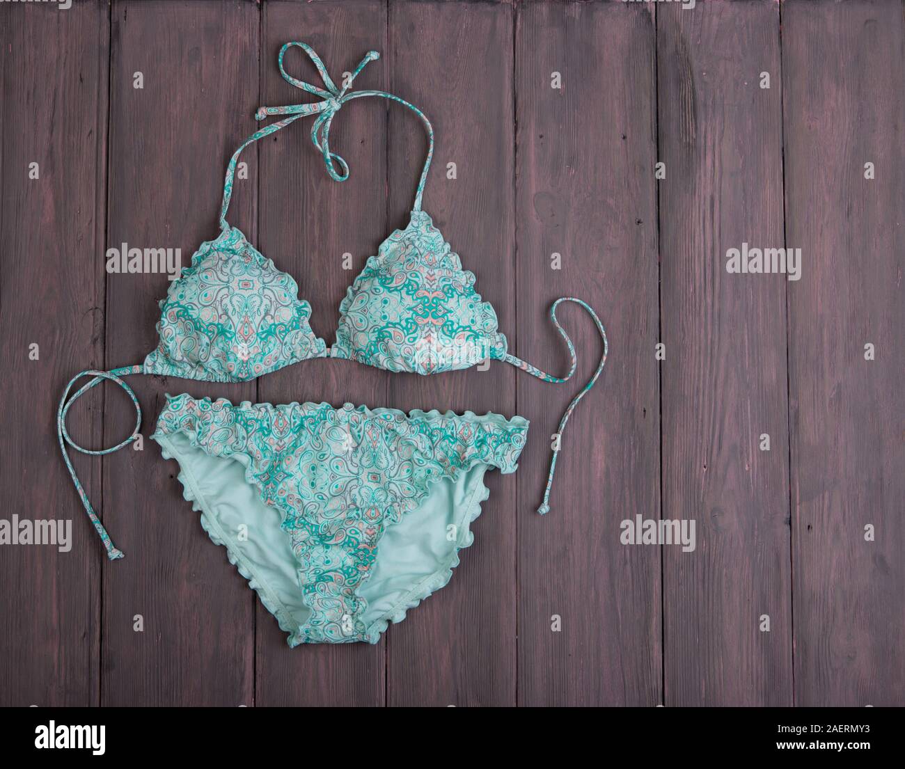 Sea holidays / travel concept - blue beautiful swimsuit in ornament on wooden background Stock Photo