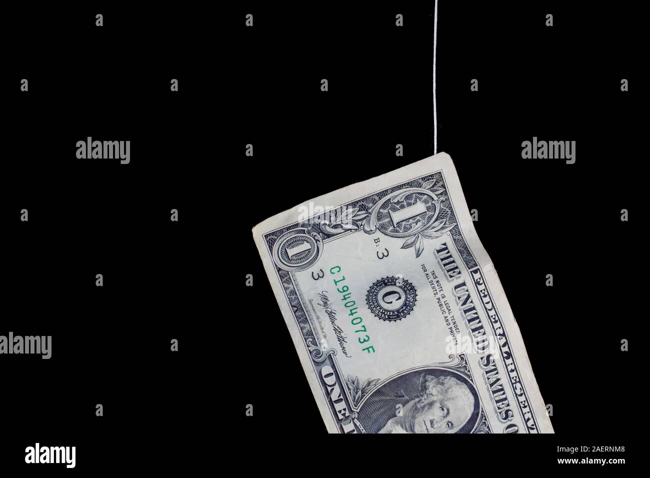 Money hanging on a thread, concept of risky financing, black background Stock Photo