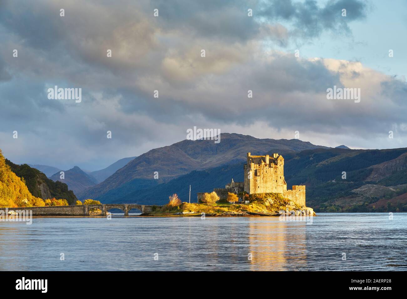 The spectacular scene of the castle on Eileen Donan island being illuminated by the soft light from the lowering sun on an October evening Stock Photo