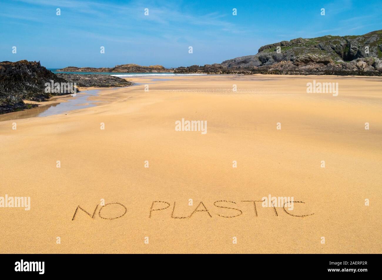 'No plastic' written in clean sand of Kiloran beach in Summer, Isle of Colonsay, Inner Hebrides, Scotland, UK Stock Photo