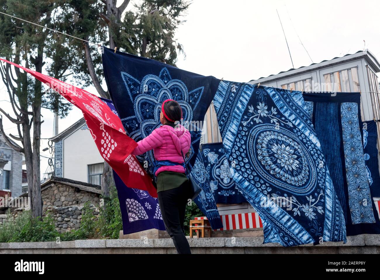 March 12, 2019: Woman doing the laundry of some typical Chinese batik in Zhoucheng, Yunnan, China Stock Photo