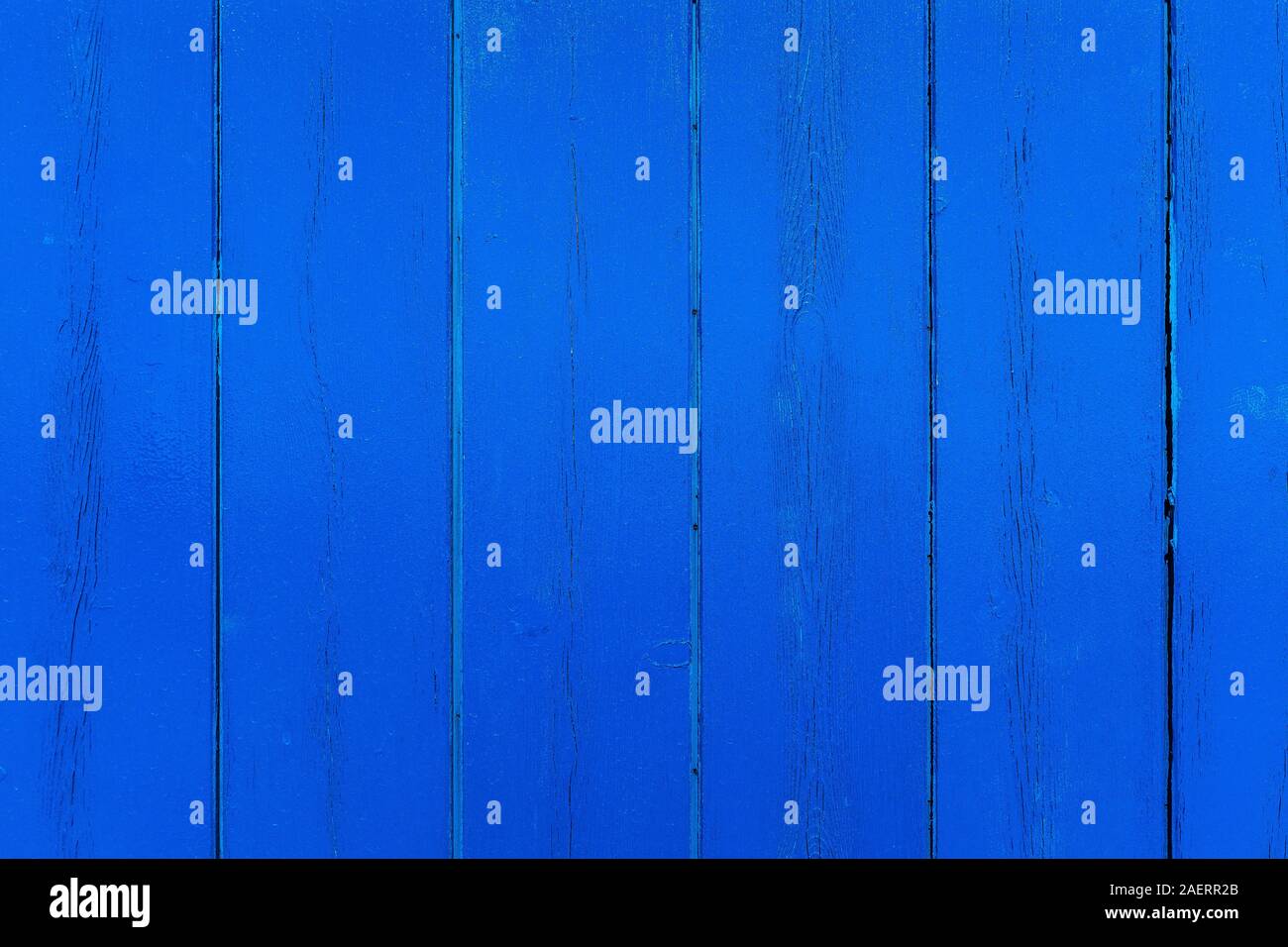 Close-up of an exterior wooden wall. Blue painted wooden planks with knots and vertical cracked. Backgrounds and textures. Copy space for text. Stock Photo