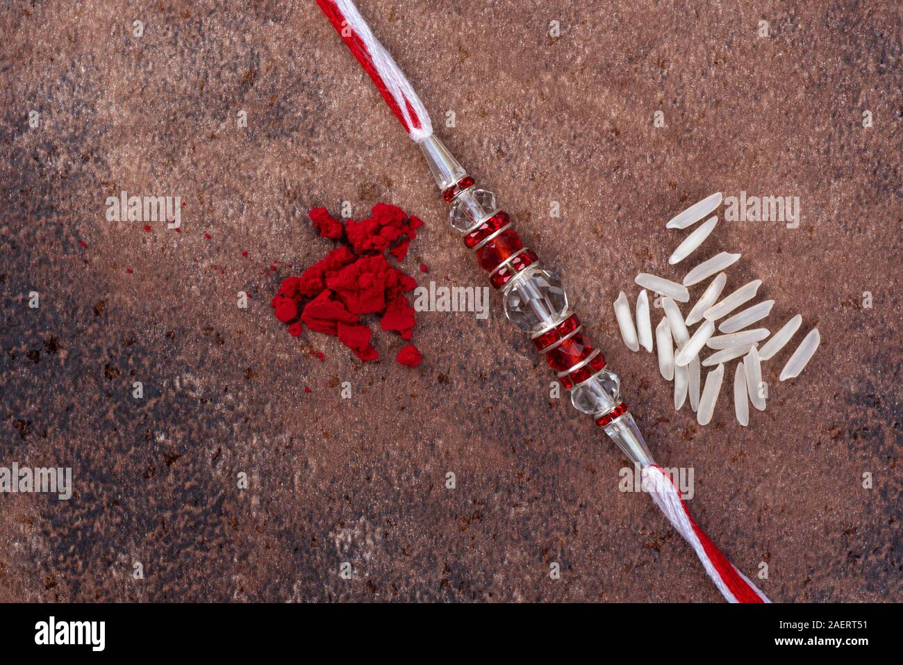 Raksha Bandhan : Rakhi with rice grains and kumkum on stone background ...