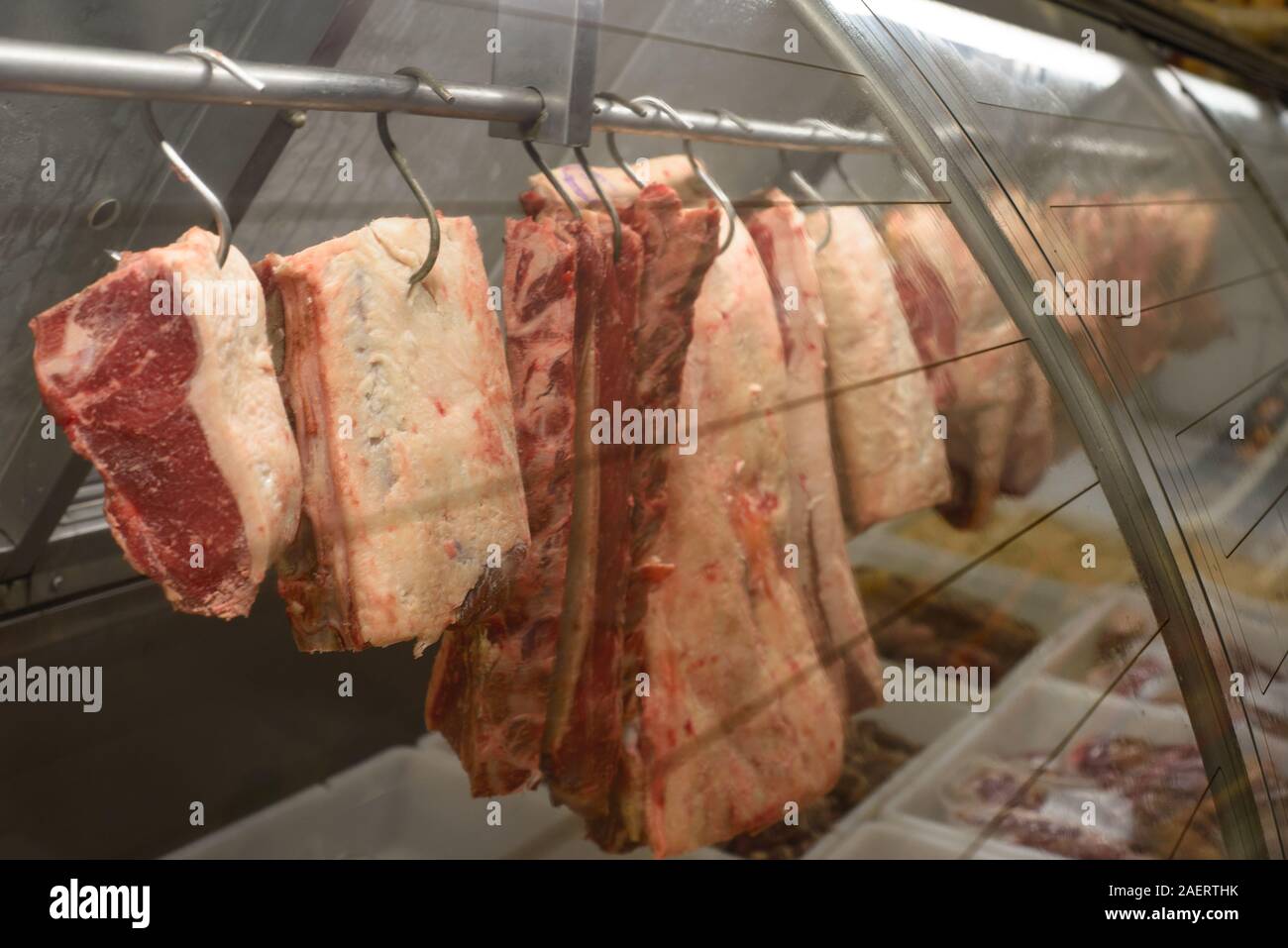 Meat hanging from hooks at the butchery Stock Photo