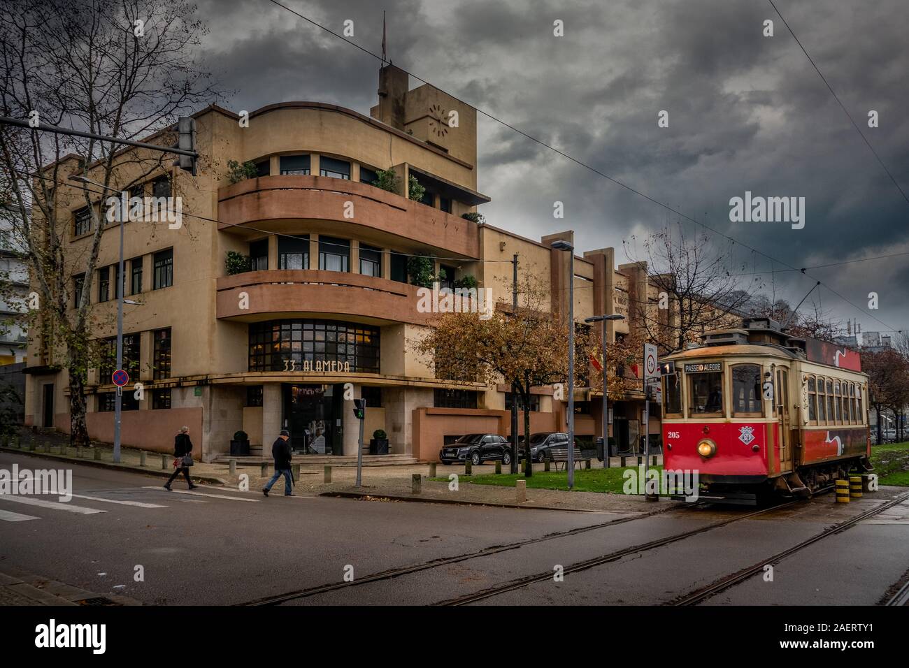 Red historic tram street car passing by an original Art Deco building in Porto Portugal Stock Photo