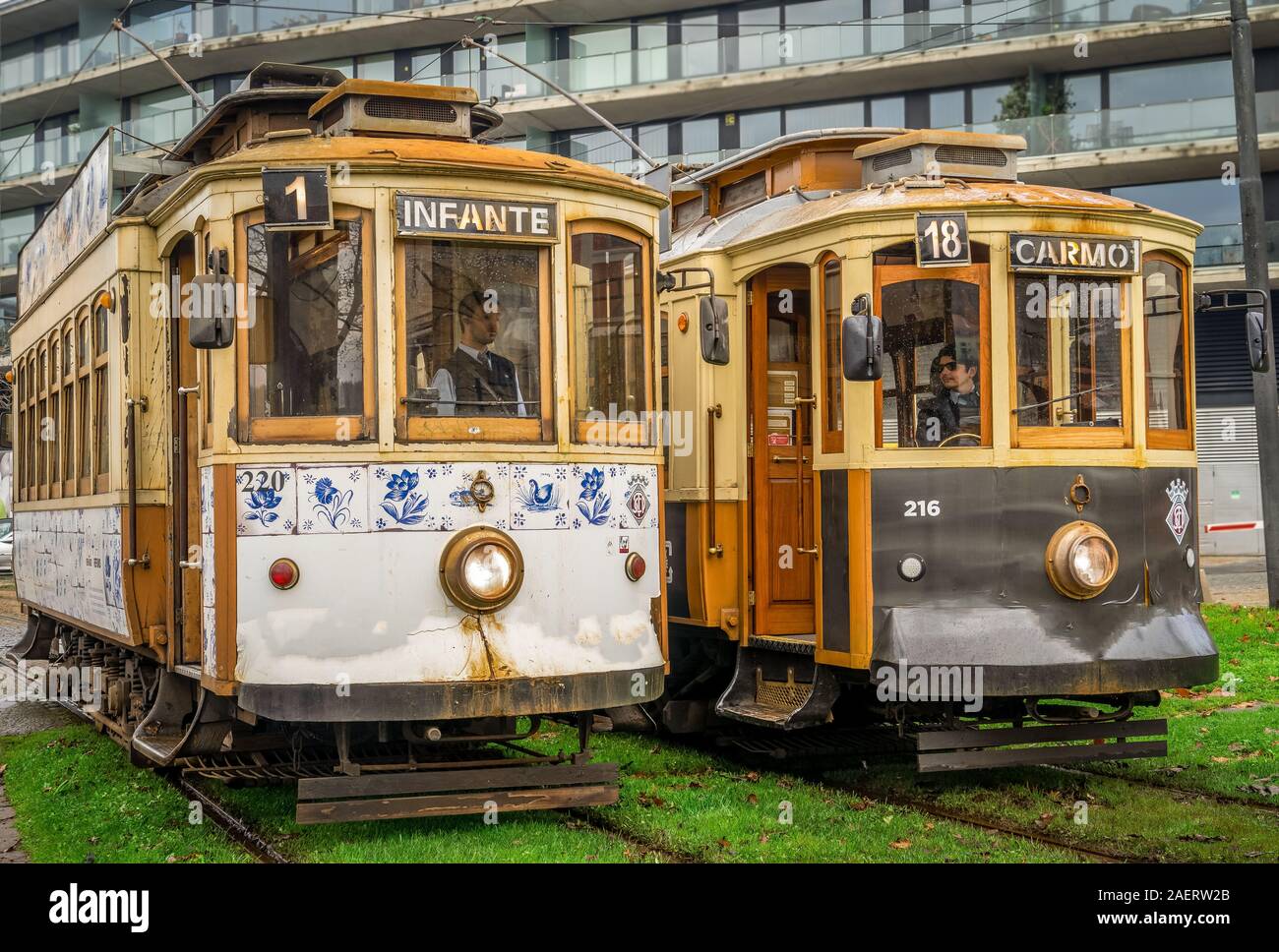 Vintage historic trams line 1 & 18 with wooden structure stand next to each other while the tram conductors chat away before they drive on in Porto Stock Photo