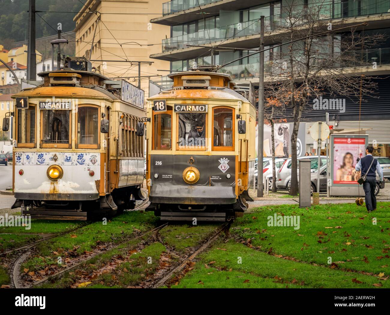 Vintage historic trams line 1 & 18 with wooden structure stand next to each other while the tram conductors chat away before they drive on in Porto Stock Photo