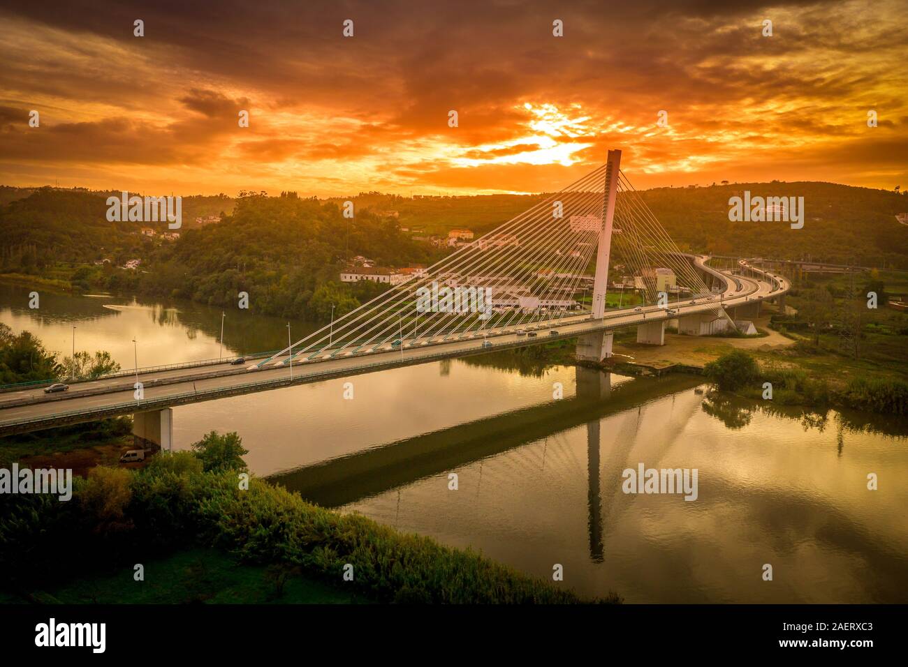 View of the Ponte Rainha Santa Isabel in Coimbra over the Mondego river with the sun setting in the back Stock Photo