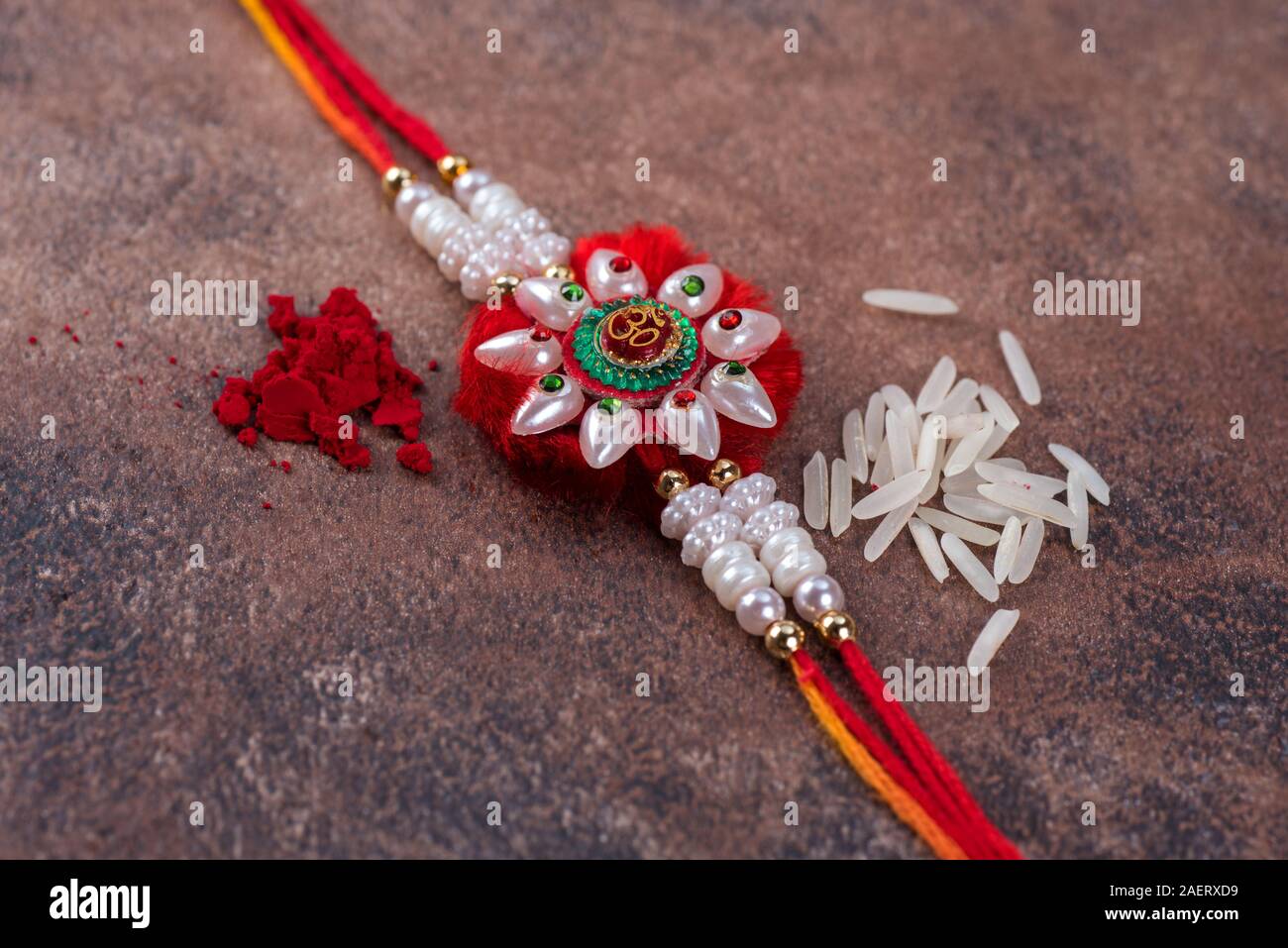 Raksha Bandhan : Rakhi with rice grains and kumkum on stone background ...