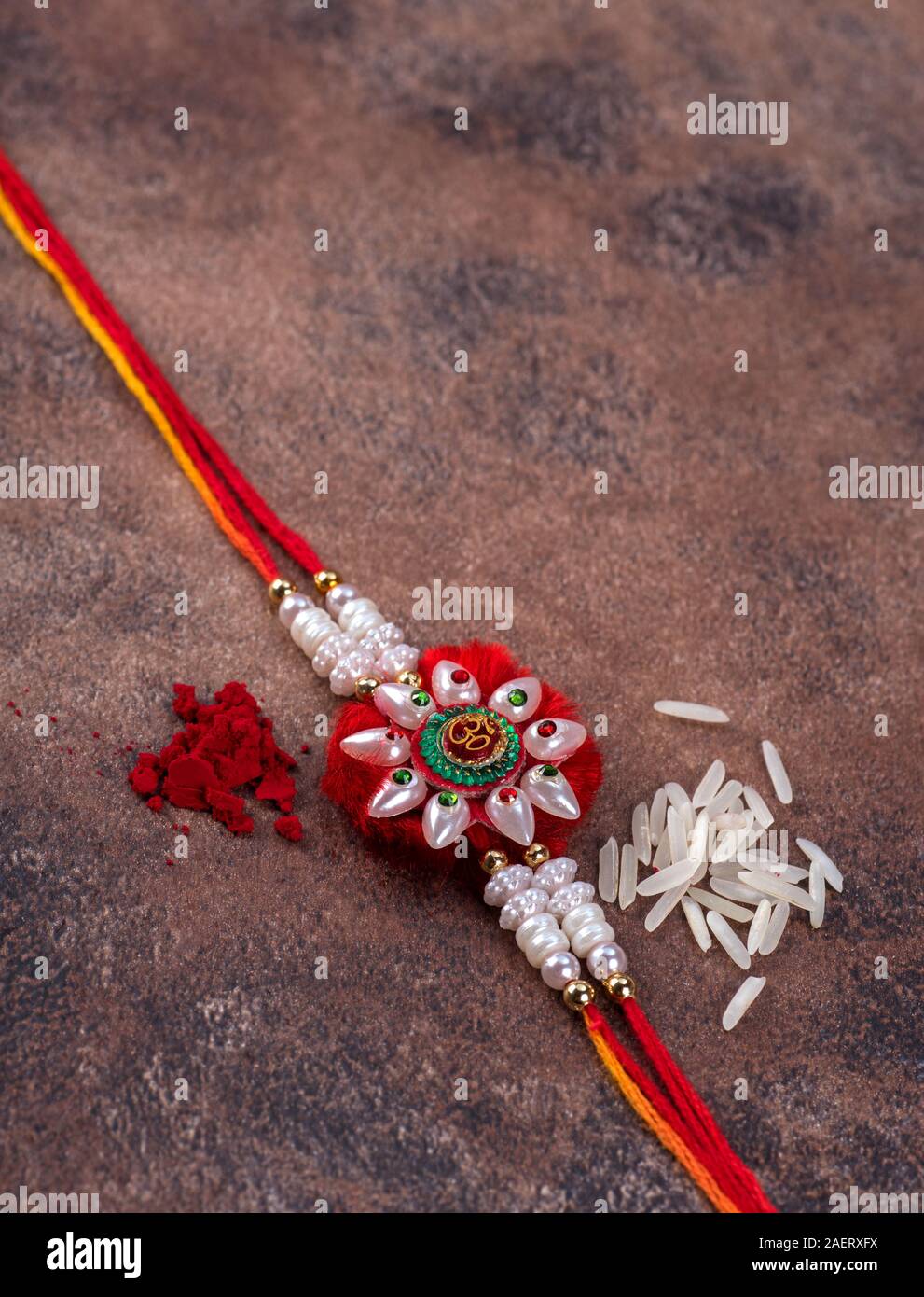 Raksha Bandhan : Rakhi with rice grains and kumkum on stone background ...