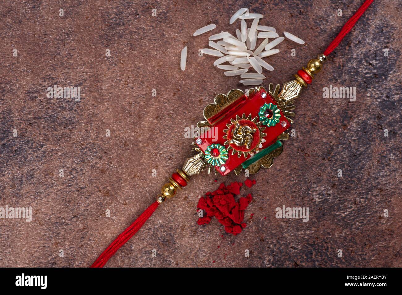 Raksha Bandhan : Rakhi with rice grains and kumkum on stone background ...