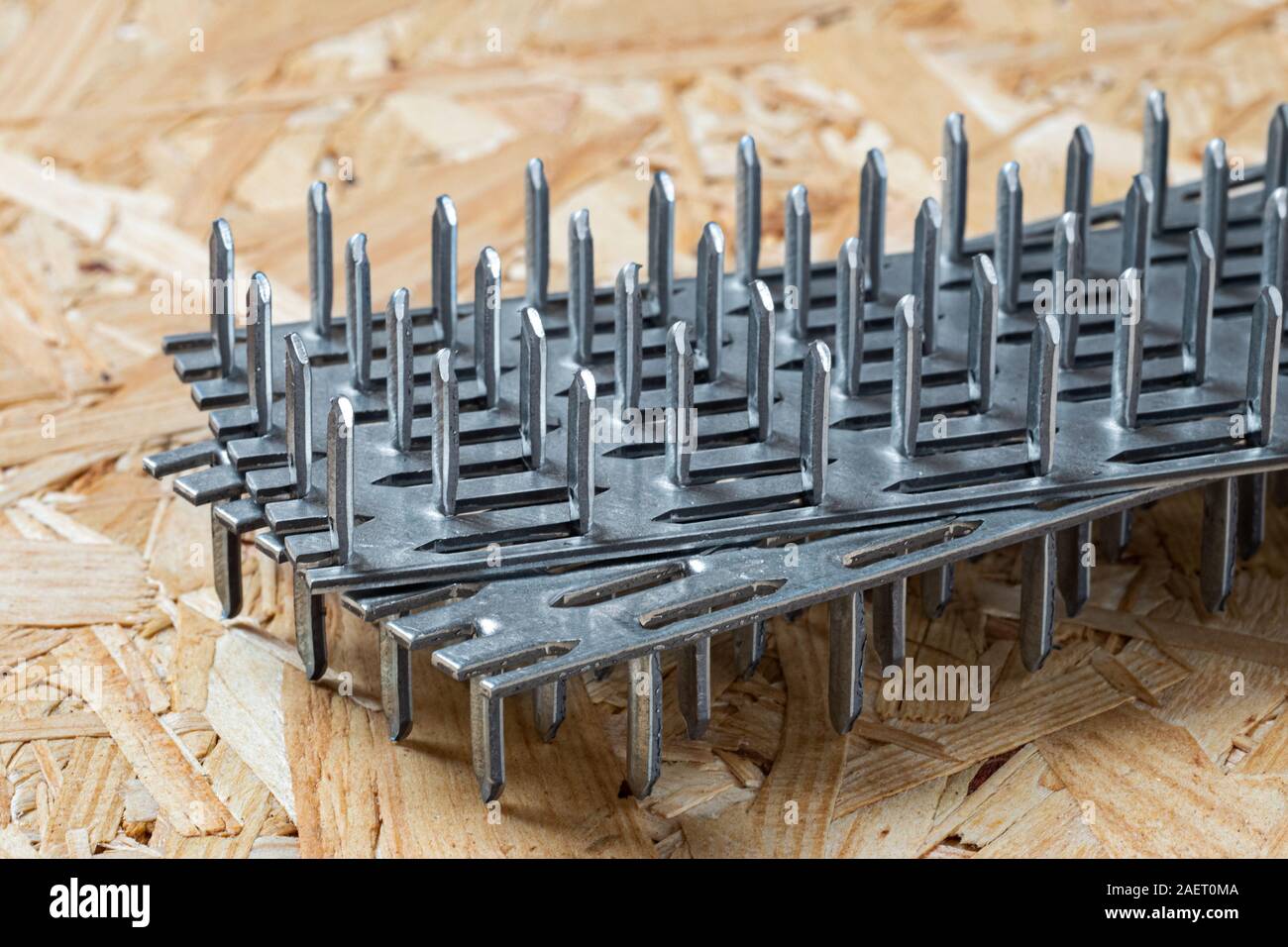 Two galvanized nail plates lying on chip board. Blurred background Stock Photo Alamy