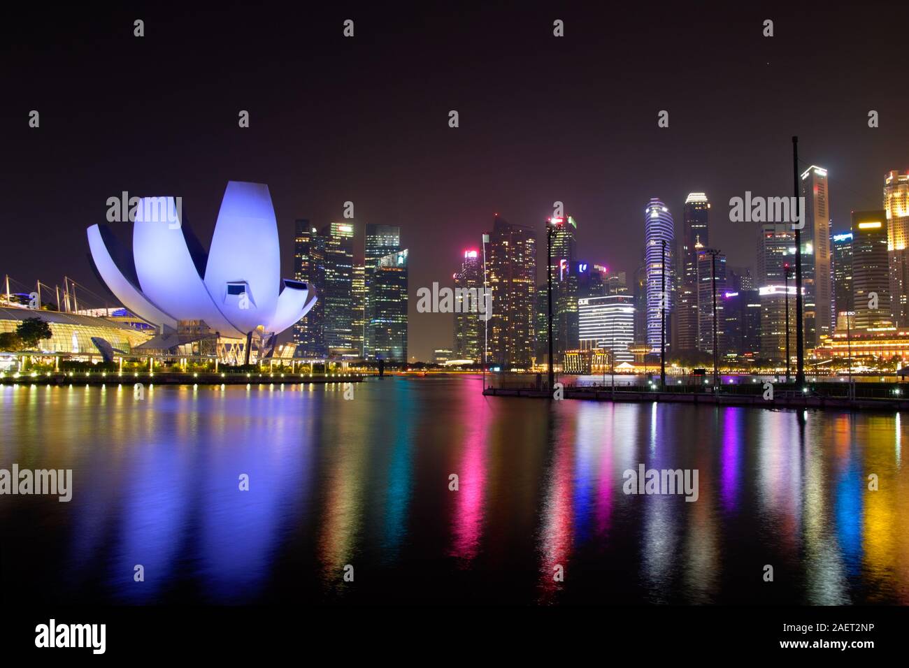 Panorama of Marina Bay water reflection colours at night, with viewpoint lotos flower shape building and skyscrapers in background Stock Photo