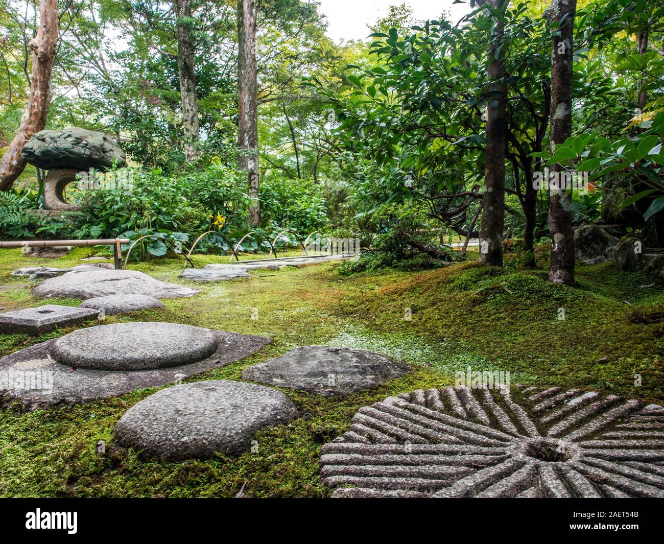 Japanese garden, moss, bamboo curved fence, tobi-ishi stepping stone grindstone pathway, Garyusanso, Ozu, Ehime, Shikoku, Japan Stock Photo