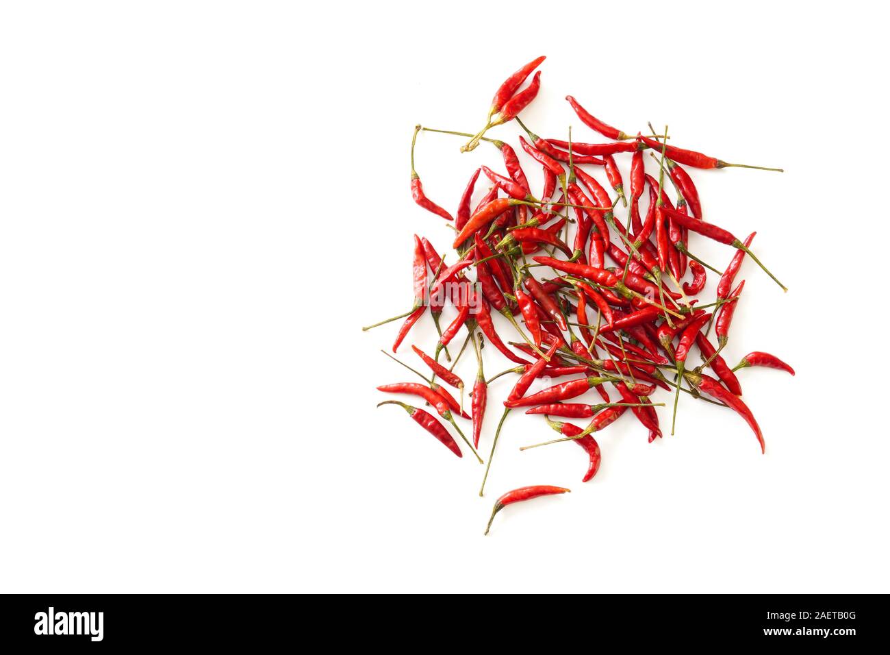 A bunch of bright red Thai bird chiles scattered on a white background with copy space; food preparation Stock Photo