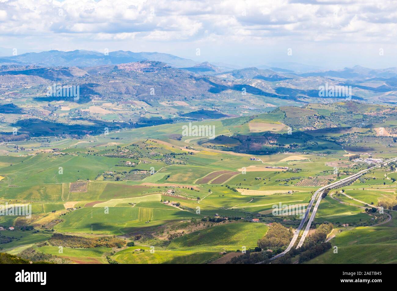 Picturesque green hilly valley near Enna city, central Sicily, Italy. The Autostrada A19 from Catania to Palermo on the background. Aerial view Stock Photo