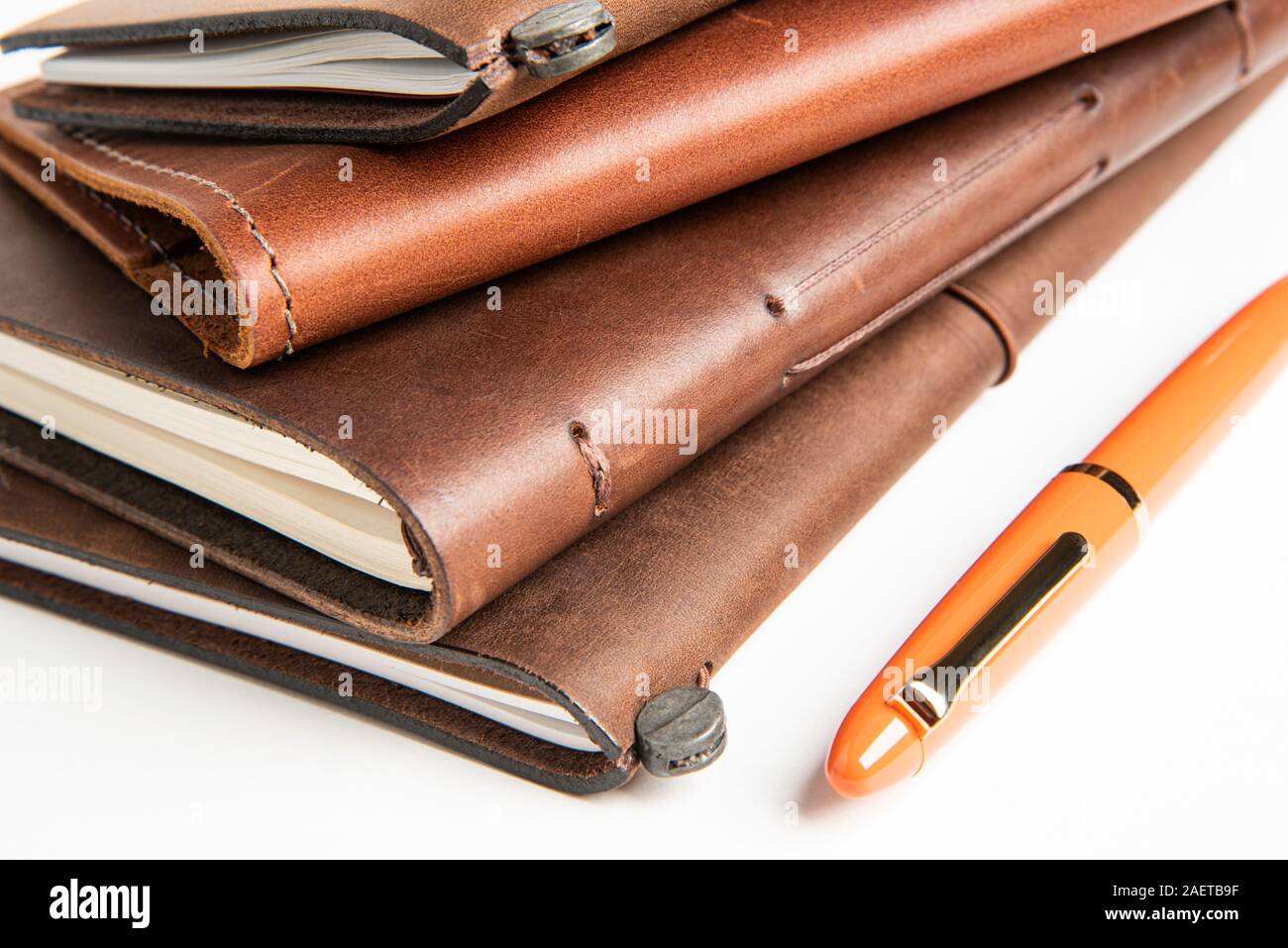 A stack of leatherbound travel writing journals with an orange