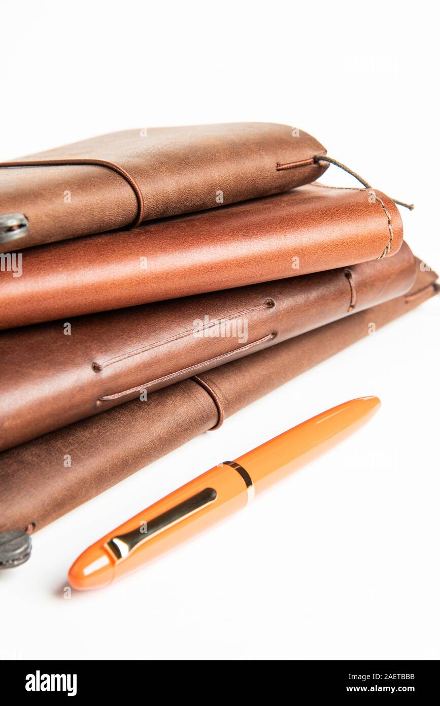 A stack of leatherbound travel writing journals with an orange