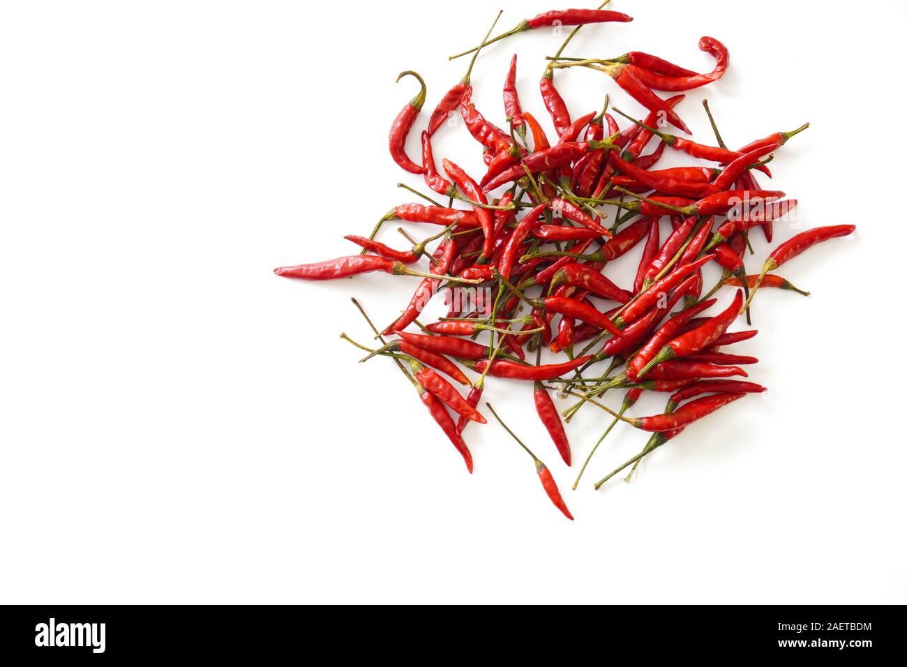 A pile of bright red Thai bird chiles scattered on an isolated white background with copy space; food preparation Stock Photo