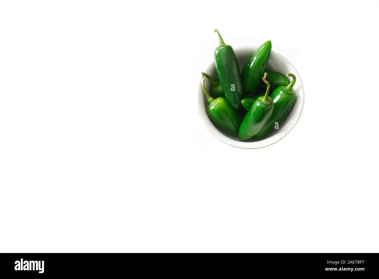 A bowl of bright green jalapeno peppers isolated on a white background with copy space; food preparation Stock Photo