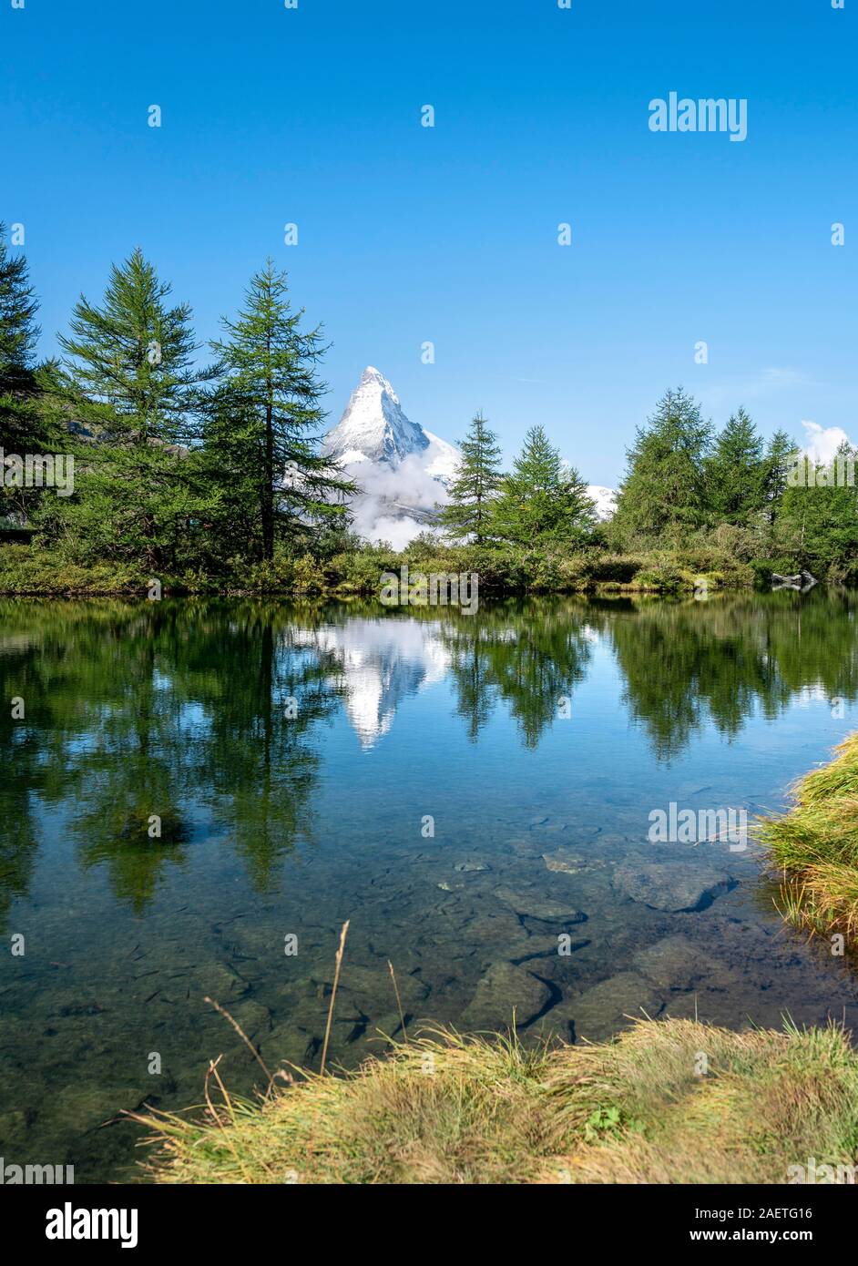 Snow-covered Matterhorn reflected in the lake, Lake Grindij, Zermatt, Wallis, Switzerland Stock Photo