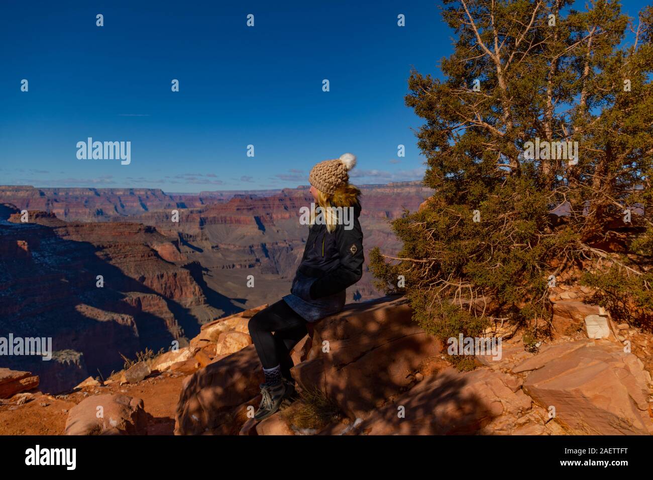 A girl sitting and looking out over the grand canyon Stock Photo