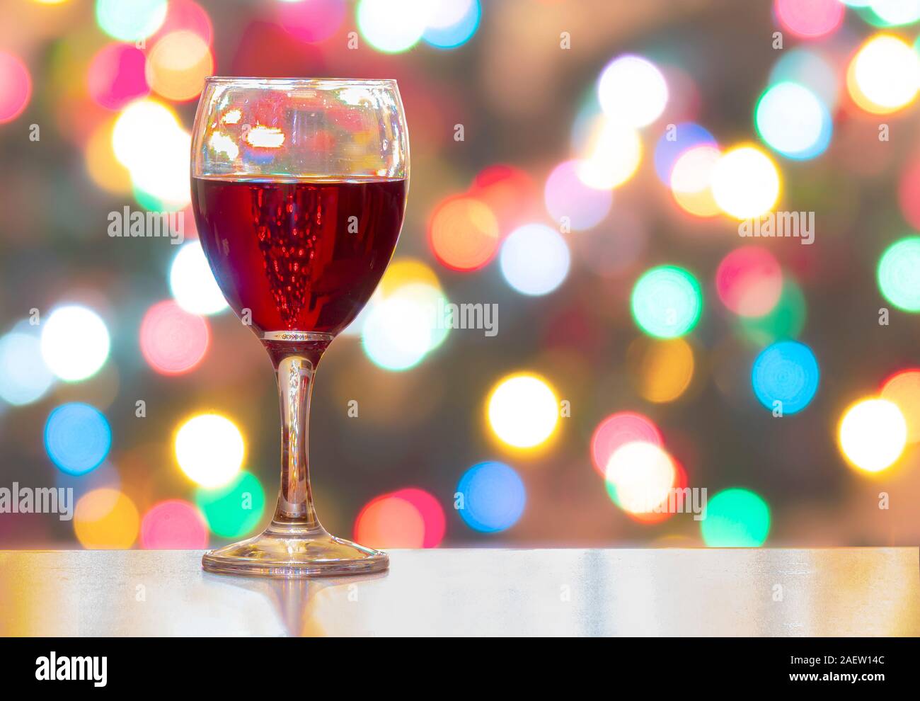 A Cup of wine with Christmas lights on the Background. Horizontal view Stock Photo