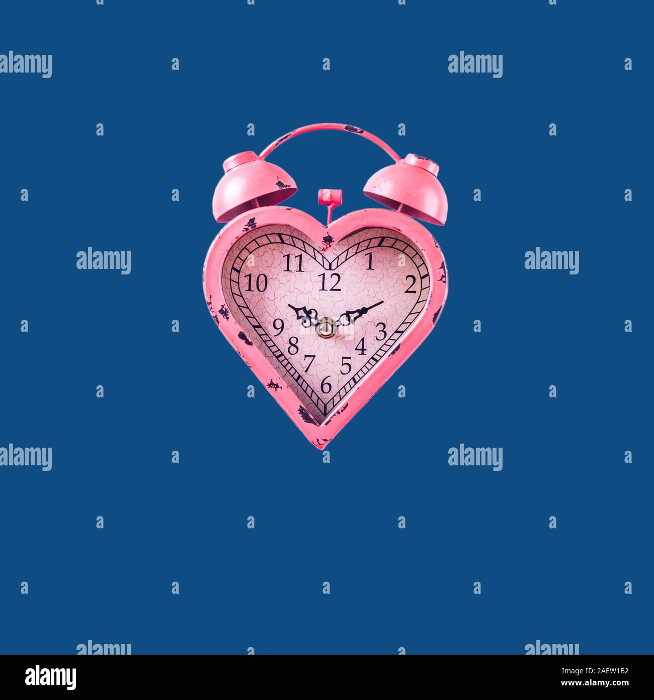 Heart shaped pink clock on classic blue background. Valentines day and ...