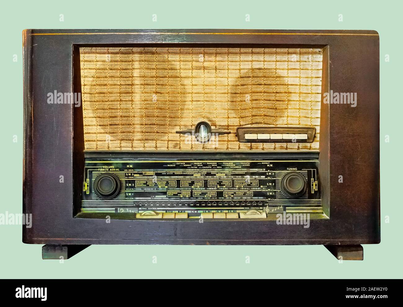 Old tube tabletop radio in wooden case, on isolated pale green background with clipping path. Stock Photo