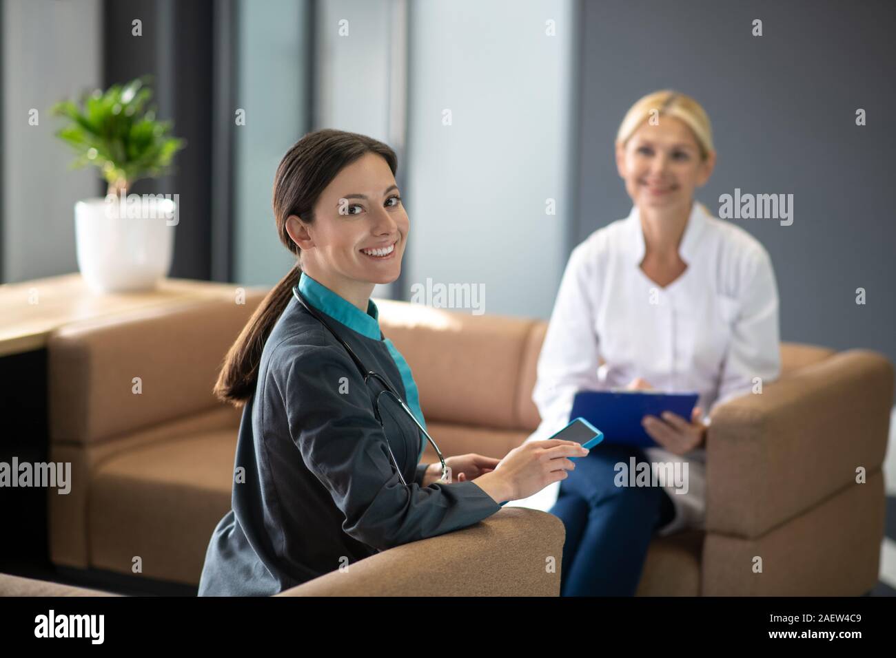 Dark-haired young female intern feeling good at work Stock Photo