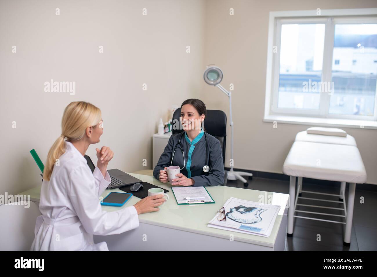 Two women having a conversation in a light room Stock Photo