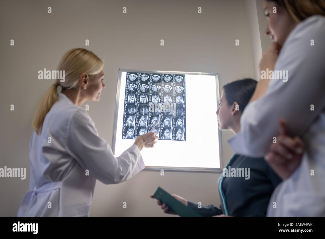 Blond doctor explaining mri scan to her colleagues Stock Photo