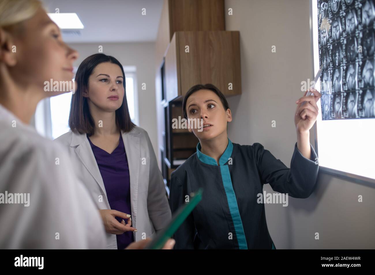Three female doctors discussing mri brains scan Stock Photo