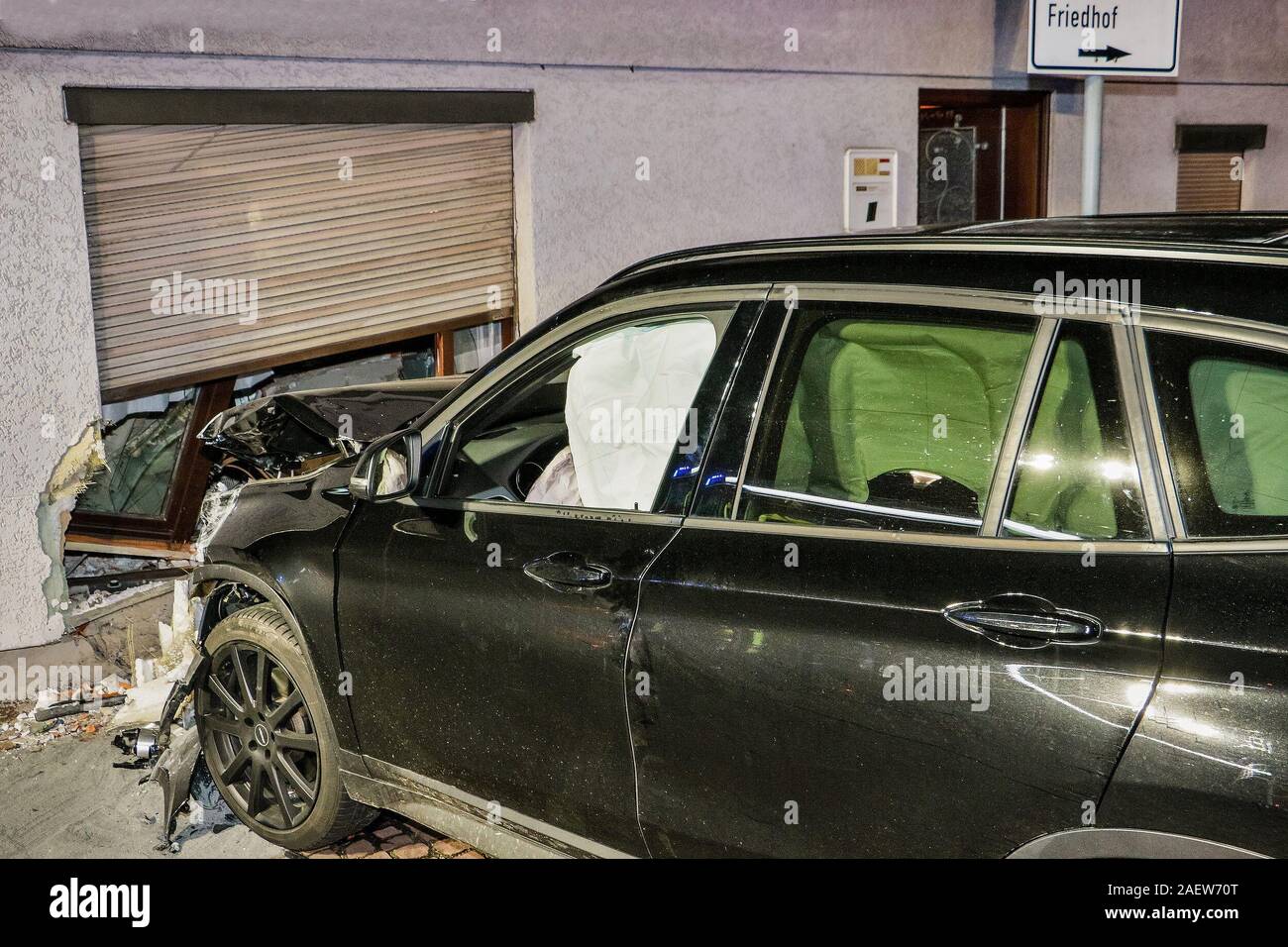 Gerlingen, Germany. 11th Dec, 2019. A car with a destroyed bonnet stands in front of a partially smashed living room wall of a detached house. A 26-year-old female driver probably left the road in a left-hand bend and entered the house frontally, probably as a result of speeding too high. According to initial findings, the resident and the 26-year-old remained uninjured. The house was so badly damaged that it is in danger of collapsing. Credit: Andreas Rometsch/KS-Images.de/dpa/Alamy Live News Stock Photo