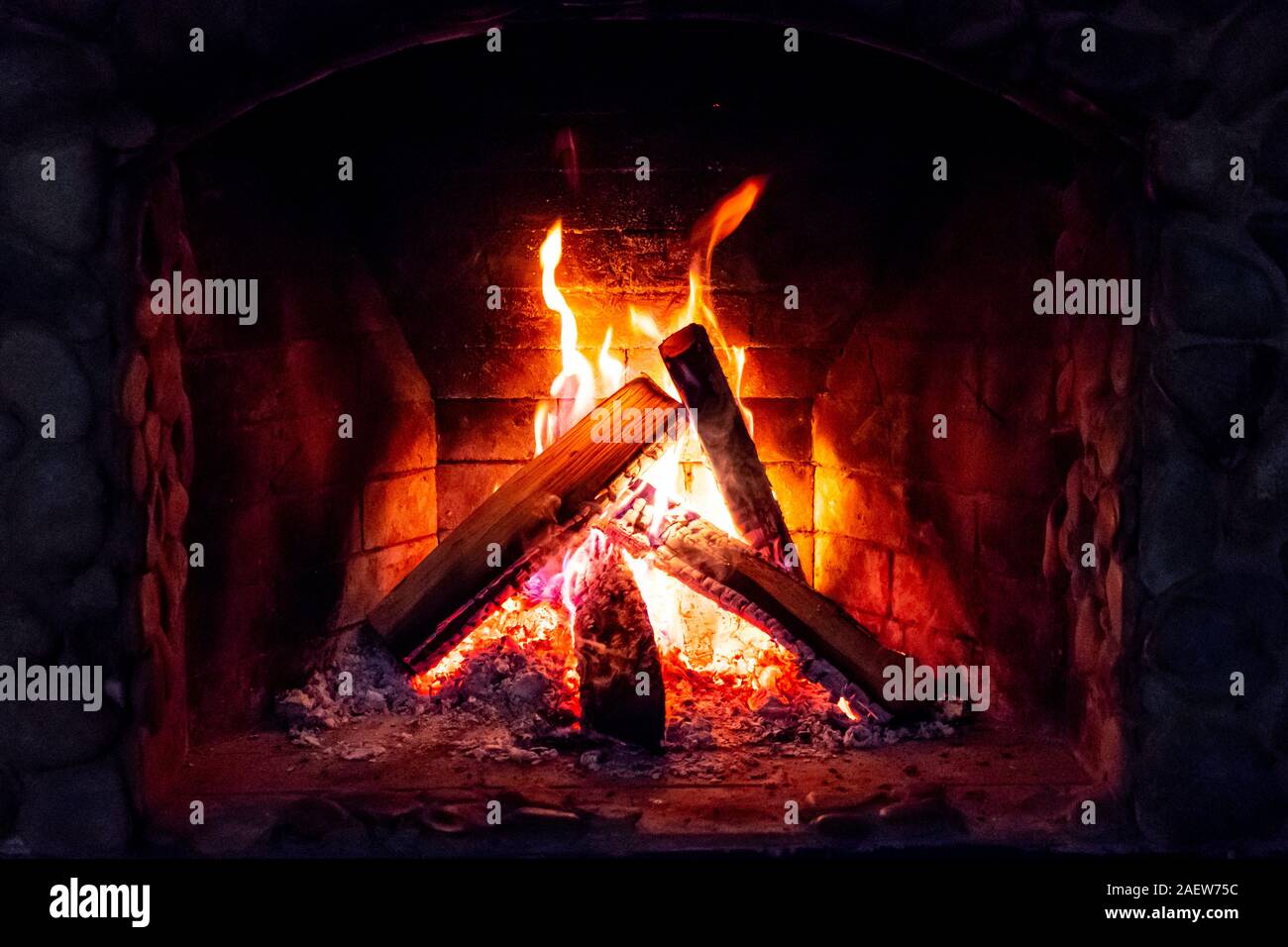 Flames in the fireplace. Burning wood. Brick fireplace Stock Photo