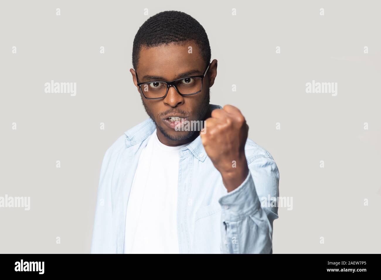 Angry annoyed african american millennial man showing clenched fist. Stock Photo