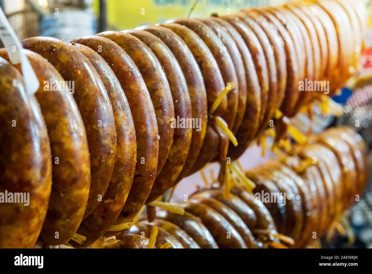 Smoked sausage hanging over the grill. The process of Smoking sausage. Cooking street food on grill Stock Photo