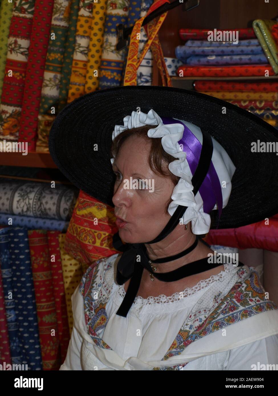 Woman in local costume in a Provencal fabric store during tallship inToulon Stock Photo