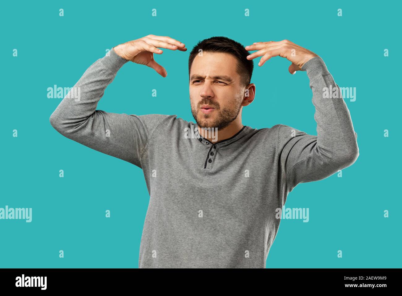 portrait of furious enraged bearded man shouting and screaming isolated on blue background Stock Photo