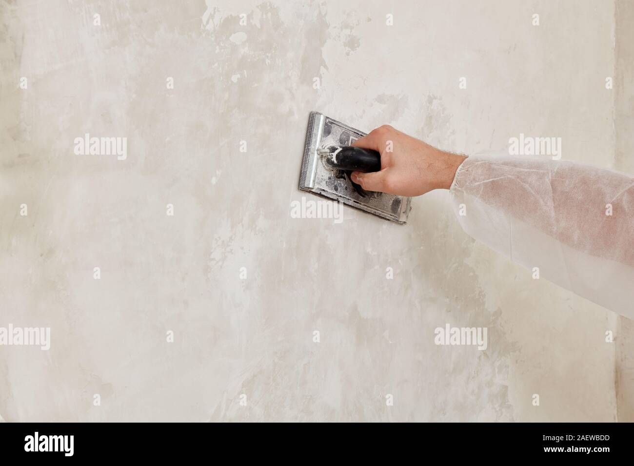 Hand of a man sanding a wall after plastering Stock Photo Alamy