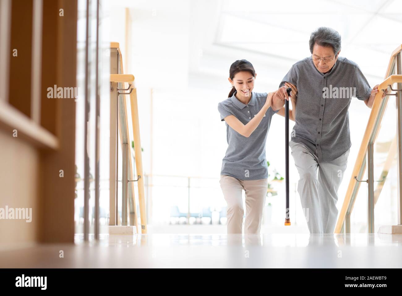 Young nurse helping elderly man walking up stairs Stock Photo Alamy