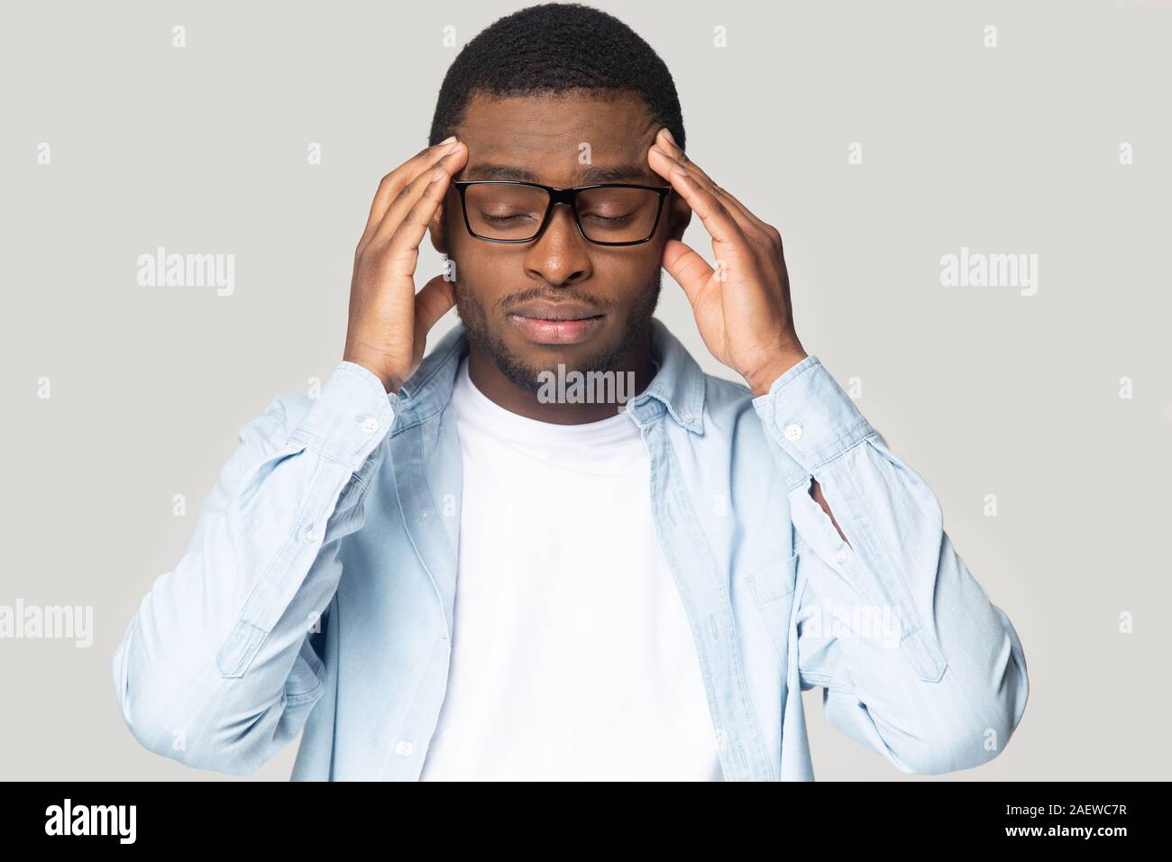Tired unhealthy young african american guy having high blood pressure. Stock Photo