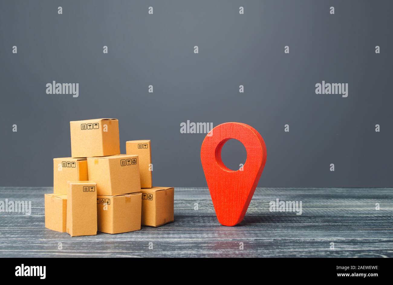 Red location pointer geolocation symbol and cardboard boxes. Distribution delivery of goods, freight transportation shipment. Logistics and warehousin Stock Photo