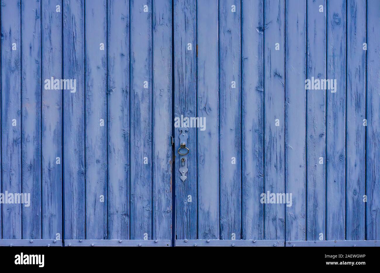 A rustic old barn door, painted lavender blue, in Provence, France. Stock Photo
