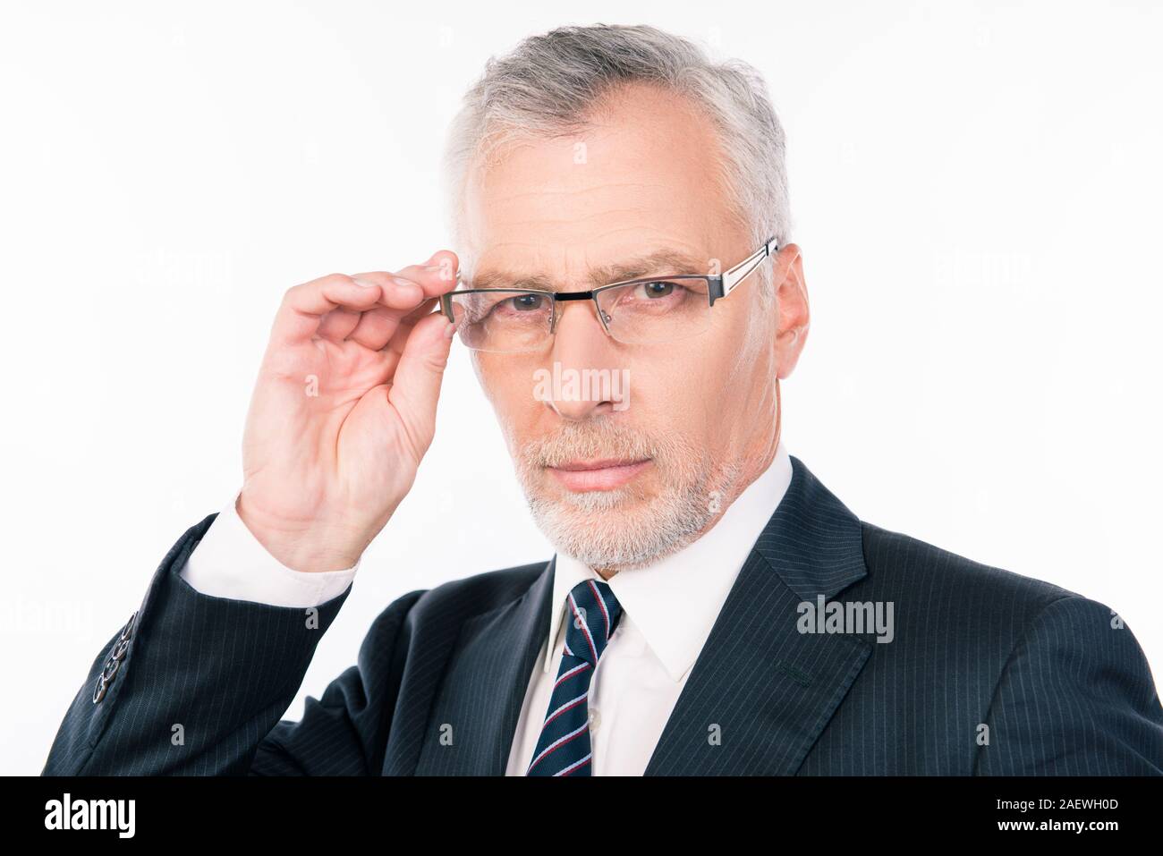 handsome serios businessman with gray beard holding glasses Stock Photo