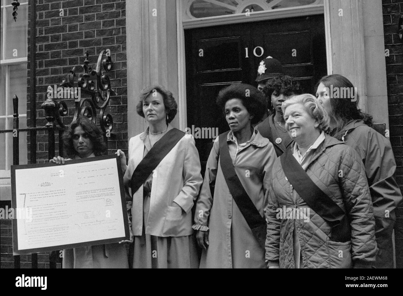 Opposition leader Neil Kinnock's wife Glenys (2nd left) and Mahatma Gandhi's adopted grandchild Shanti Naidoo (l) hold a facsimile of the Trust Deed granted to the people of Kwa Ng ema in 1904 by the Lt-Governor of the Transvaal on behalf of Edward VII. Mrs Kinnock and Shanti are among a group of women who admire the work of Black Sash in South Africa and delivered the document to PM Margaret Thatcher, with a letter asking her to intervene on behalf of the people of Kwa Ngema to ensure they are allowed to remain on their land. Currently about 160 families live there, but they are threatened by Stock Photo
