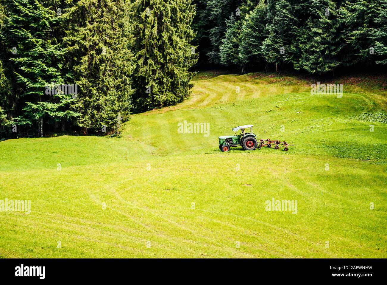 old tractor standing on a field in bavarian alps Stock Photo