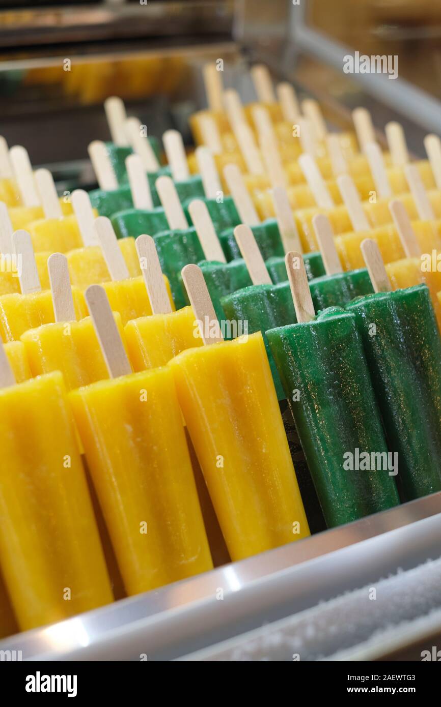 Fresh natural pure fruit juice flavoured ice lollies on wooden sticks