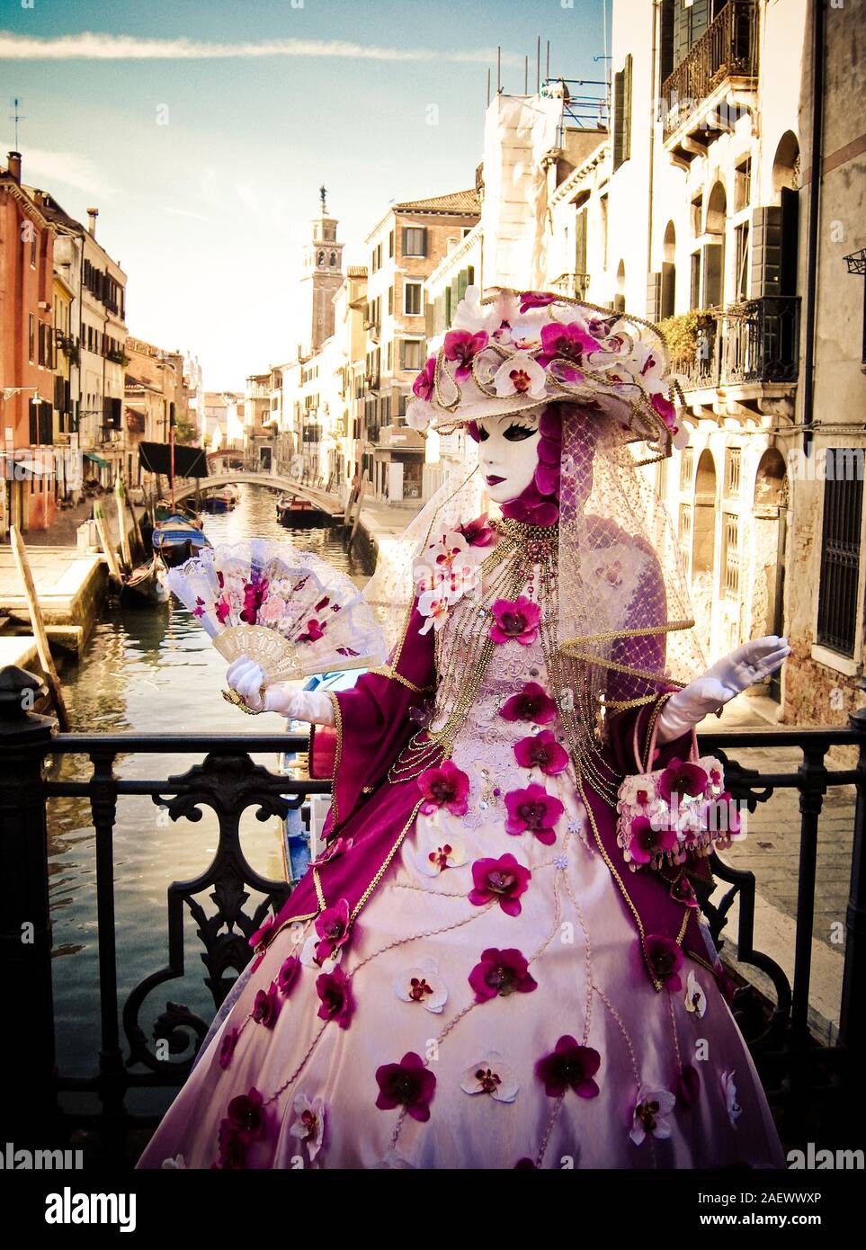 Masquerade in Venice, in rich exquisite costumes and masks, fan, hat with flowers, Italy