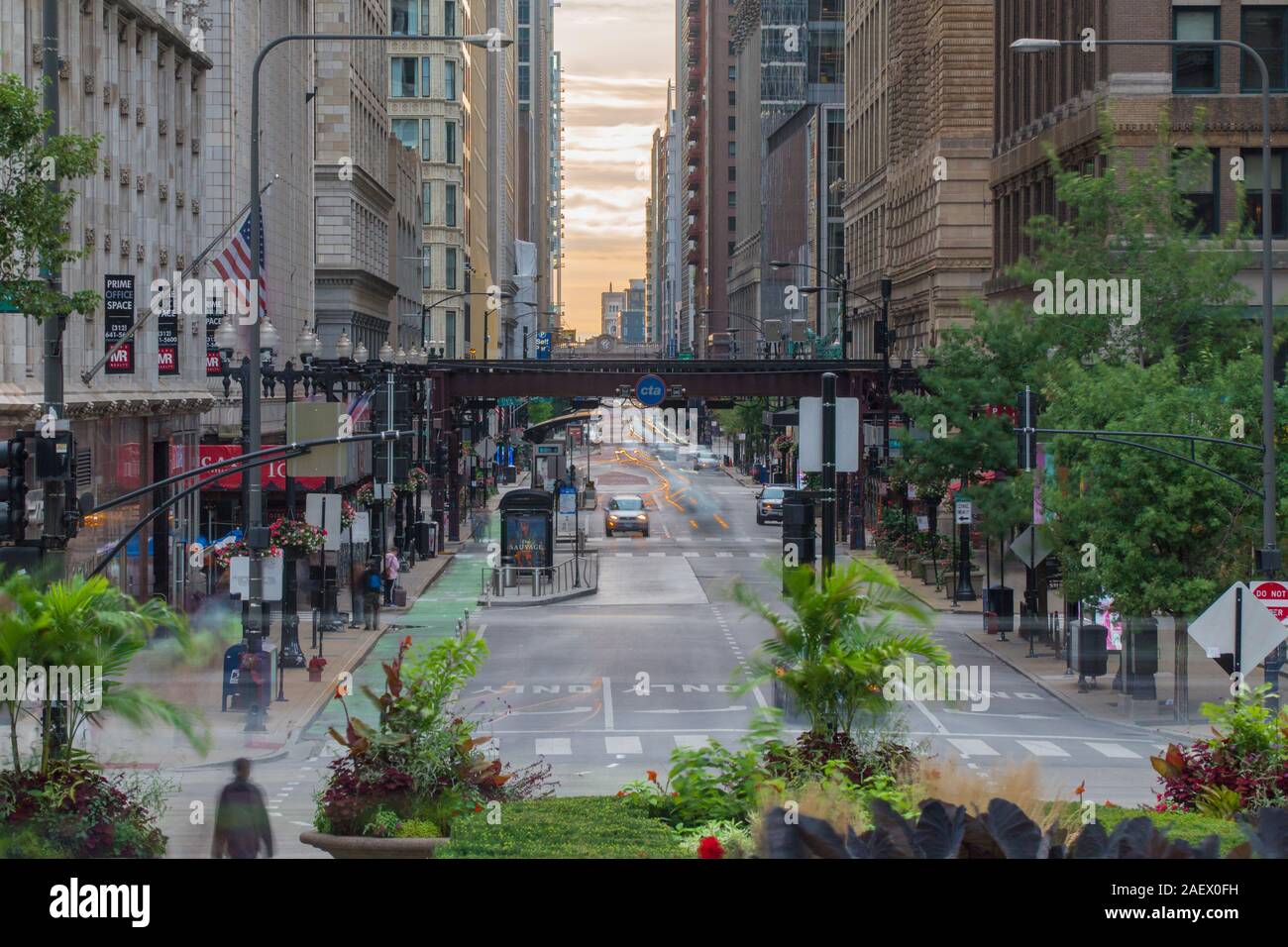 Chicago, IL - Circa 2019: Downtown Chicago day time long exposure of morning street traffic busy movement through road intersection under loop train t Stock Photo